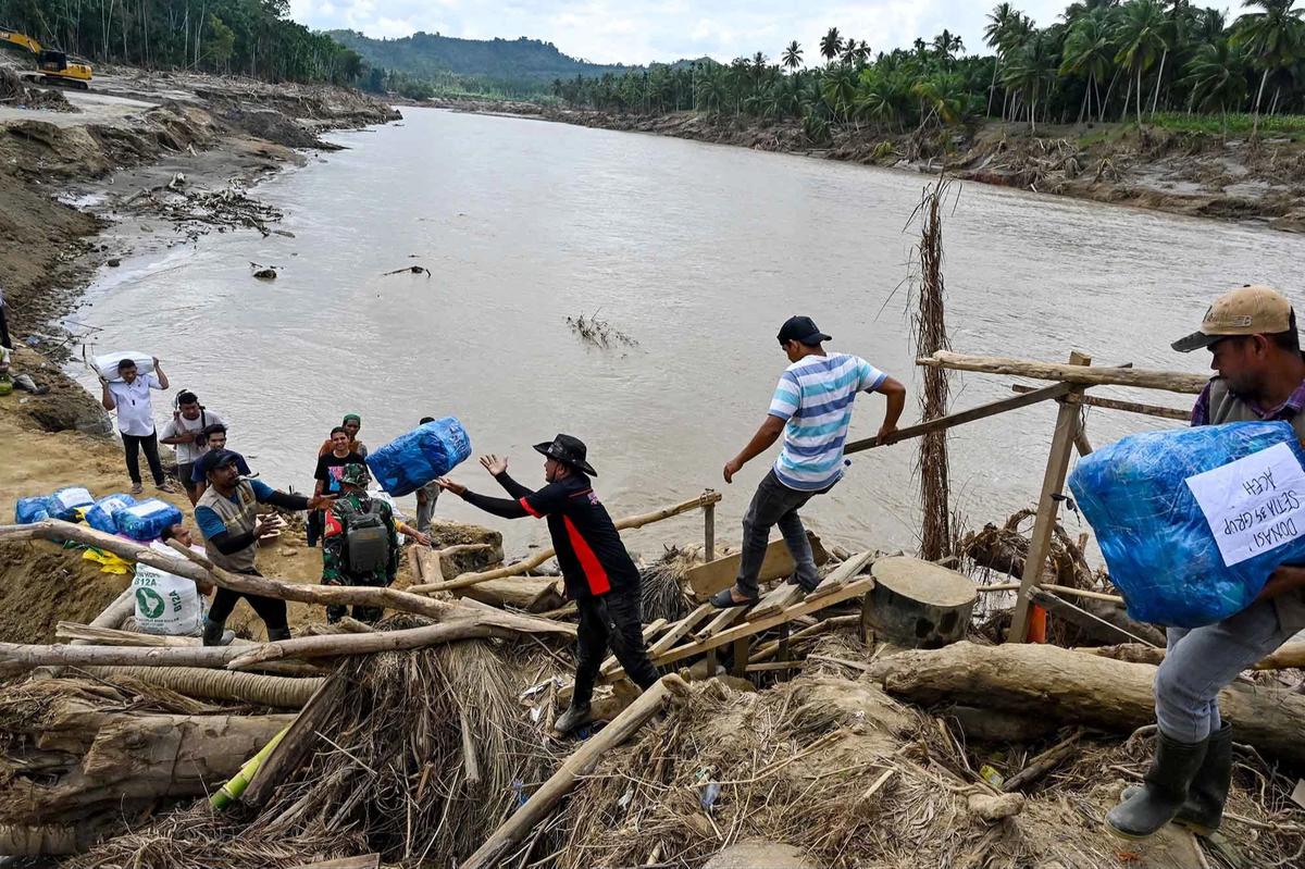 FOTO: Warga Memanjat Puing Kayu Demi Menyeberangi Sungai Peusangan