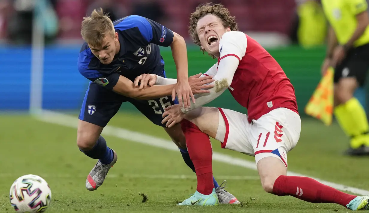 Penyerang timnas Finlandia, Marcus Forss berebut bola dengan penyerang Denmark, Andreas Skov Olsen pada laga Grup B Euro 2020 di Parken Stadium, Sabtu (12/6/2021). Selain tumbang 0-1, tuan rumah juga terpukul menyusul insiden yang melibatkan Christian Eriksen.  (AP Photo/Martin Meissner, Pool)