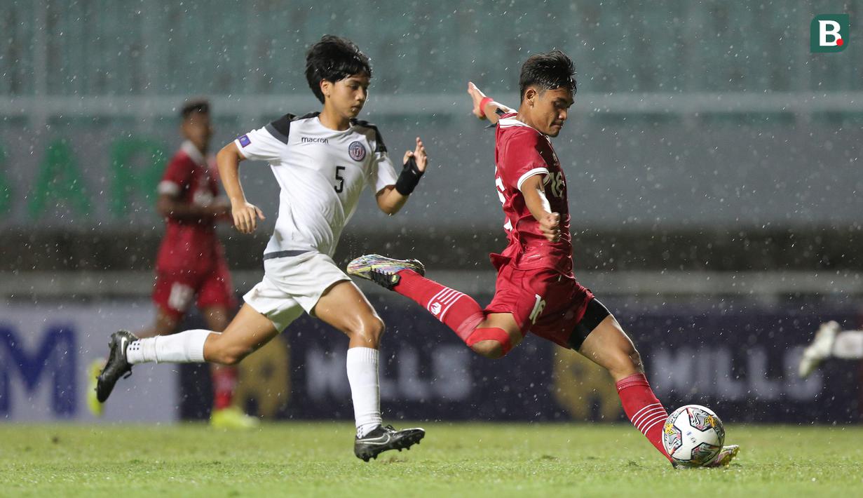 <p>Pemain Timnas Indonesia U-17, Muhammad Gaoshirowi (kanan)&nbsp;menendang bola ke gawang Timnas Guam U-17 dalam pertandingan Grup B Kualifikasi Piala Asia U-17 2023 yang berlangsung di Stadion Pakansari, Bogor, Senin (3/10/2022). (Bola.com/Bagaskara Lazuardi)</p>