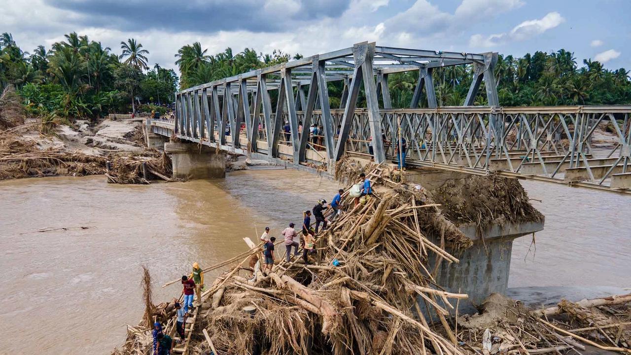 FOTO: Warga Memanjat Puing Kayu Demi Menyeberangi Sungai Peusangan