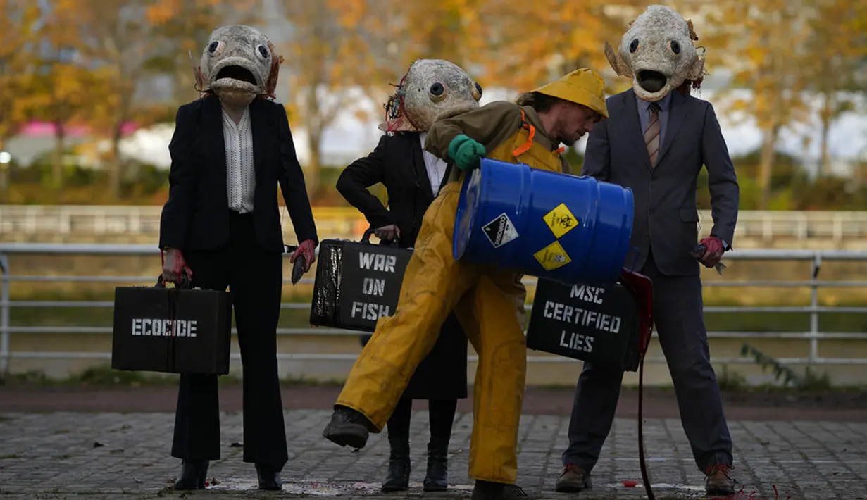Juru kampanye dari kelompok lingkungan Ocean Rebellion mengenakan topeng kepala ikan saat aksi protes terhadap Marine Stewardship Council (MSC) di Glasgow, Skotlandia, 4 November 2021. Aksi ini dilakukan di sela-sela KTT Iklim PBB COP26 yang sedang berlangsung. (AP Photo/Alastair Grant)