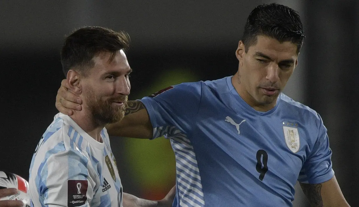 Penyerang Argentina Lionel Messi menyapa penyerang Uruguay Luis Suarez sebelum laga Kualifikasi Piala Dunia 2022 Zona Amerika Selatan di Monumental stadium, Senin (11/10/2021) pagi WIB. Duel ini menjadi momen reuni dua mantan pemain Barcelona, Messi dan Suarez. (Juan Mabromata/AFP)