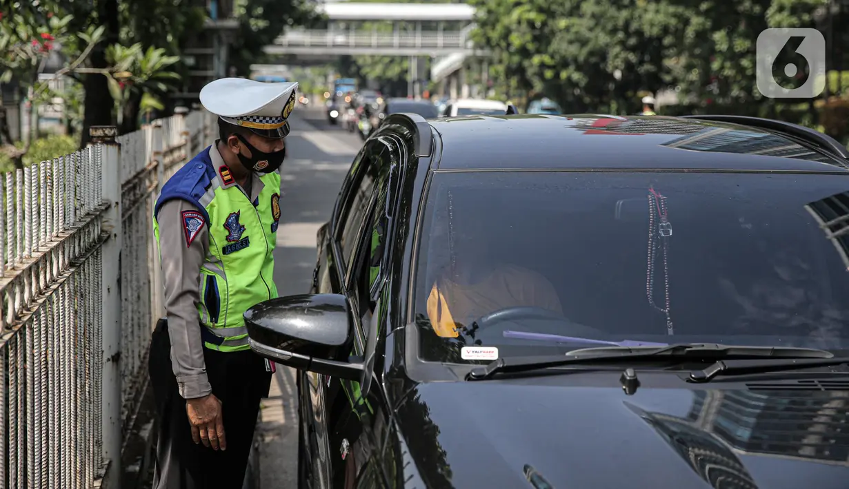 Polisi lalu lintas berkomunikasi dengan pengendara mobil saat Operasi Zebra Jaya 2022 di Jakarta, Selasa (4/10/2022). Operasi Zebra Jaya dilaksanakan pada tanggal 3 hingga 17 Oktober untuk menekan jumlah pelanggaran lalu lintas. (Liputan6.com/Faizal Fanani)