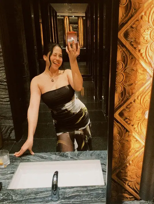 Sitha Marino mengunggah potret mirror selfienya yang menggemaskan. Penampilannya sempurna dengan balutan strapless dress berwarna hitam bermotif abstrak. Dress ini memiliki detail bagian rok yang semi transparan. [Foto: Instagram/sithamarino]