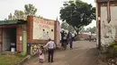 <p>Orang tua mengantar anaknya ke sekolah pada hari pertama pembukaan kembali setelah hampir dua tahun penutupan lembaga pendidikan di Kampala pada 10 Januari 2022. Sekolah-sekolah di Uganda dibuka kembali, mengakhiri penutupan sekolah terlama di dunia akibat pandemi COVID-19. (Badru KATUMBA/AFP)</p>