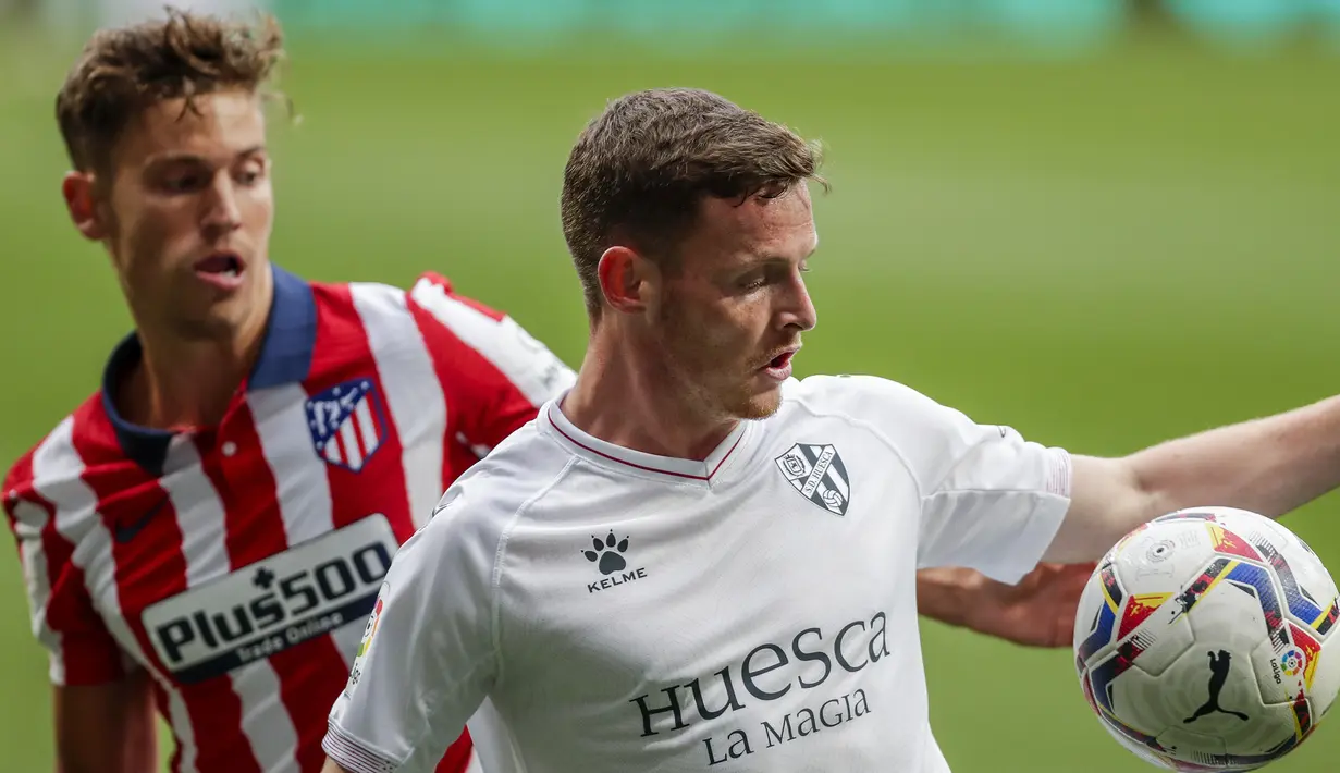 Gelandang SD Huesca, Sergio Gomez (kanan) menguasai bola dibayangi gelandang Atletico Madrid, Marcos Llorente dalam laga lanjutan Liga Spanyol 2020/2021 pekan ke-32 di Wanda Metropolitano Stadium, Madrid, Kamis (22/4/2021). SD Huesca kalah 0-2 dari Atletico Madrid. (AP/Manu Fernandez)