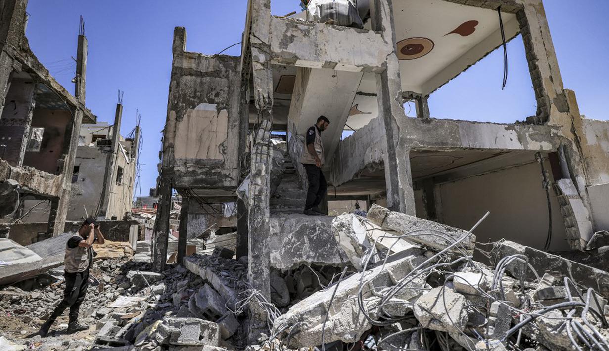 Pakar bahan peledak Hamas mencari proyektil yang tidak meledak dari reruntuhan bangunan setelah konflik Mei 2021 dengan Israel di Kota Gaza, Sabtu (5/6/2021). Perang 11 hari antara Hamas dan Israel menewaskan 254 orang Palestina dan 12 orang Israel. (MAHMUD HAMS/AFP)