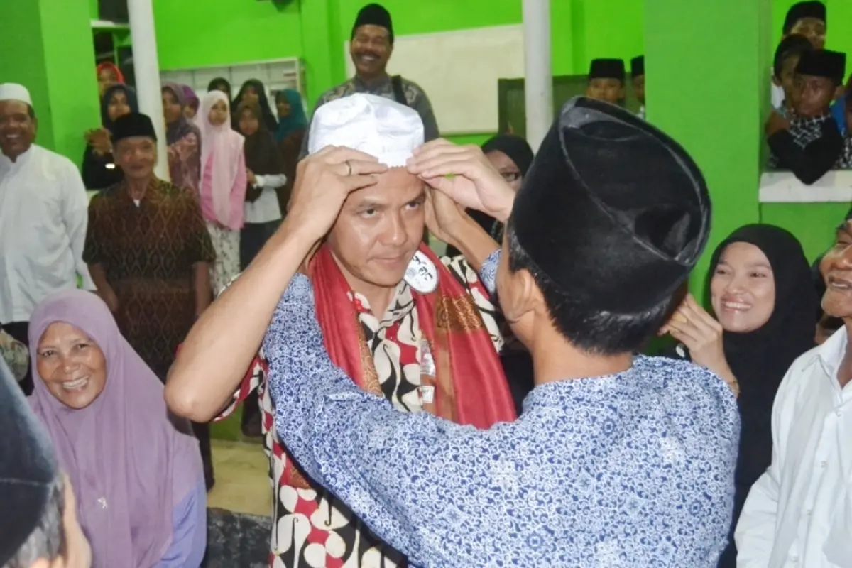 Seorang santri di Ponpes El Bayan, Majenang, Cilacap, memakaikan kopyah kepada Gubernur Jawa Tengah, Ganjar Pranowo. (Foto: Liputan6.com/Muhamad Ridlo)