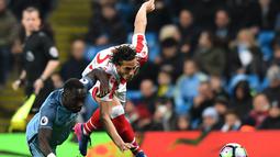 Pemain Manchester City,  Bacary Sagna (kiri) berebut bola dengan pemain Stoke City, Ramadan Sobhi pada lanjutan Premier League di Etihad Stadium, (8/3/2017). Manchester City bermain imbang 0-0.  (AFP/Anthony Devlin)