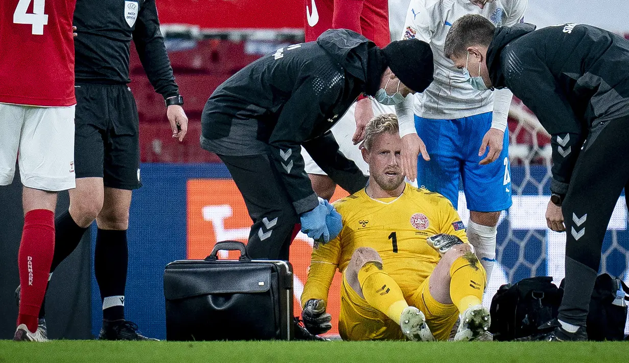 Kiper Denmark, Kasper Schmeichel, mendapat perawatan dari tim medis dalam laga UEFA Nations League Grup A2 melawan Islandia di Parken Stadium, Copenhagen, Denmark, Senin (16/11/2020) dini hari WIB. Denmark unggul 2-1 atas Islandia. (AFP/Liselotte Sabroe/Ritzau Scanpix).