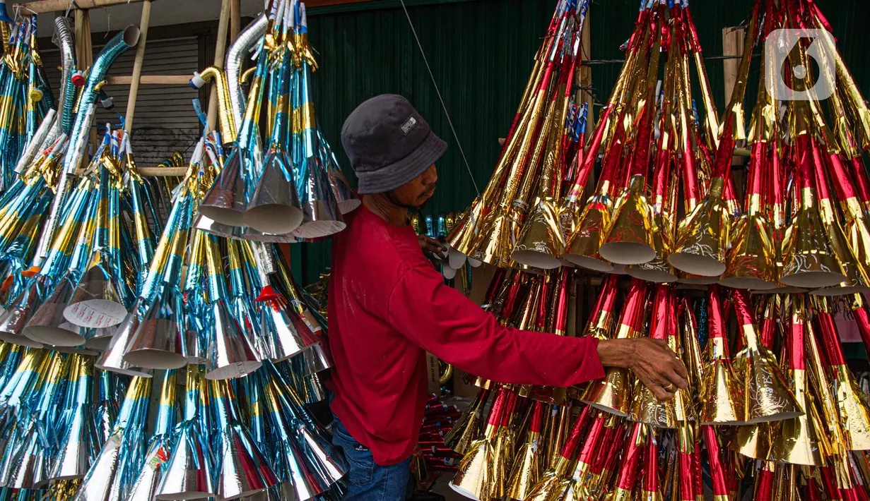 Pedagang menata terompet buatannya untuk dijual di kawasan Glodok, Jakarta, Selasa (26/12/2023). (Liputan6.com/Faizal Fanani)