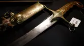 Sebuah pedang berikut sarungnya yang berukir yang diberikan kepada Kapten Angkatan Laut Kerajaan, James Kearney White, oleh Napoleon Bonaparte ditampilkan sebelum dilelang di balai lelang Charles Miller di London pada 1 November 2024. (BENJAMIN CREMEL/AFP)