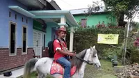 Ridwan Sururi saat selalu menunggangi kudanya setiap berkeliling dari desa ke desa untuk menarik minat baca masyarakat di kaki Gunung Slamet, Jawa Tengah. (Liputan6.com/Gunanto Eko)