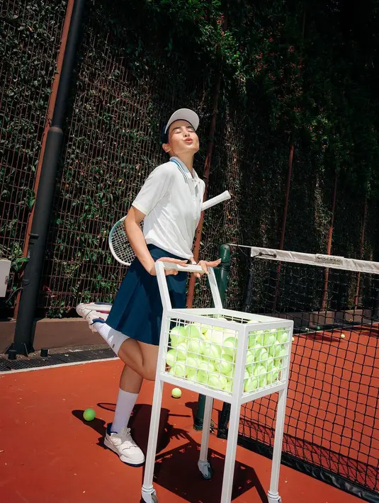 Maudy Ayunda pun kenakan outfit yang kurang lebih sama namun memiliki garis biru di bagian kerah. Maudy lengkapi outfit tennisnya dengan topi [@maudyayunda]