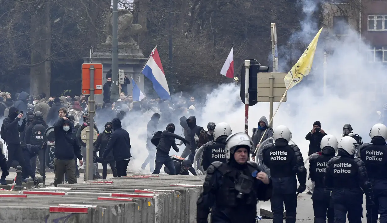 Polisi menghadapi pengunjuk rasa selama demonstrasi menentang tindakan COVID-19 di Brussels, Minggu (23/1/2022). Beberapa hari terakhir di Belgia angka jumlah orang yang terinfeksi varian omicron telah memuncak, mencapai jumlah rekor baru setiap hari. (AP Photo/Geert Vanden Wijngaert)