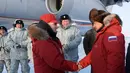 Presiden Rusia, Vladimir Putin berjabat tangan dengan Menteri Pertahanan Sergei Shoigu, saat mengunjungi Franz Josef Land di Arctic, Rusia, (29/3). (Alexei Druzhinin, Sputnik, Kremlin Pool Photo via AP)