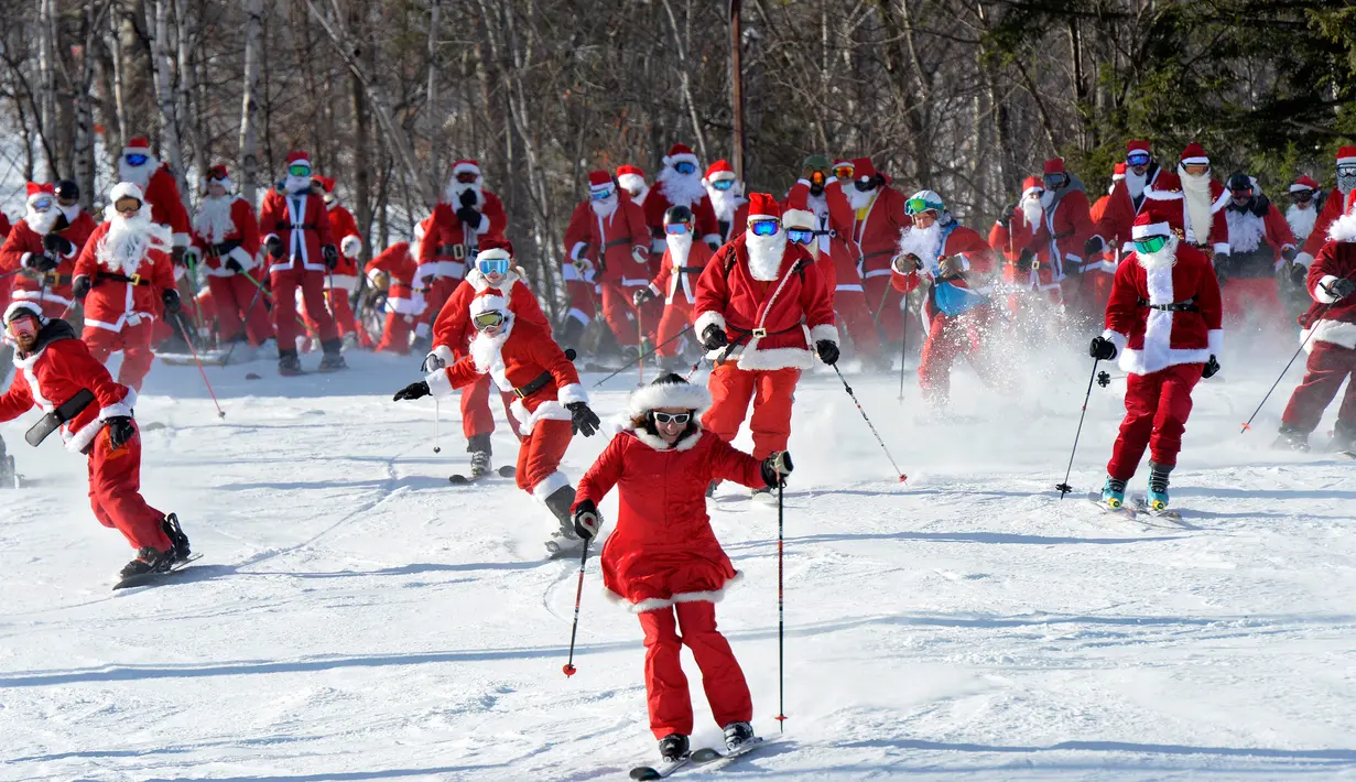 Para pemain ski berpakaian seperti Sinterklas meluncur selama berpartisipasi dalam acara tahunan Santa Sunday di Sunday River Resort yang terletak di Kota Newry, Amerika Serikat, Minggu (8/12/2019). Santa Sunday merupakan acara amal tahunan untuk River Fund Charity. (Joseph Prezioso / AFP)