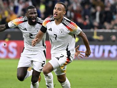 Pemain Jerman, Jamie Leweling (kanan) melakukan selebrasi bersama Antonio Rudiger setelah mencetak gol ke gawang Belanda pada laga lanjutan Grup A3 UEFA Nations League di Allianz Arena, Jerman, Selasa (15/10/2024) dini hari WIB. (AP Photo/dpa/Sven Hoppe)