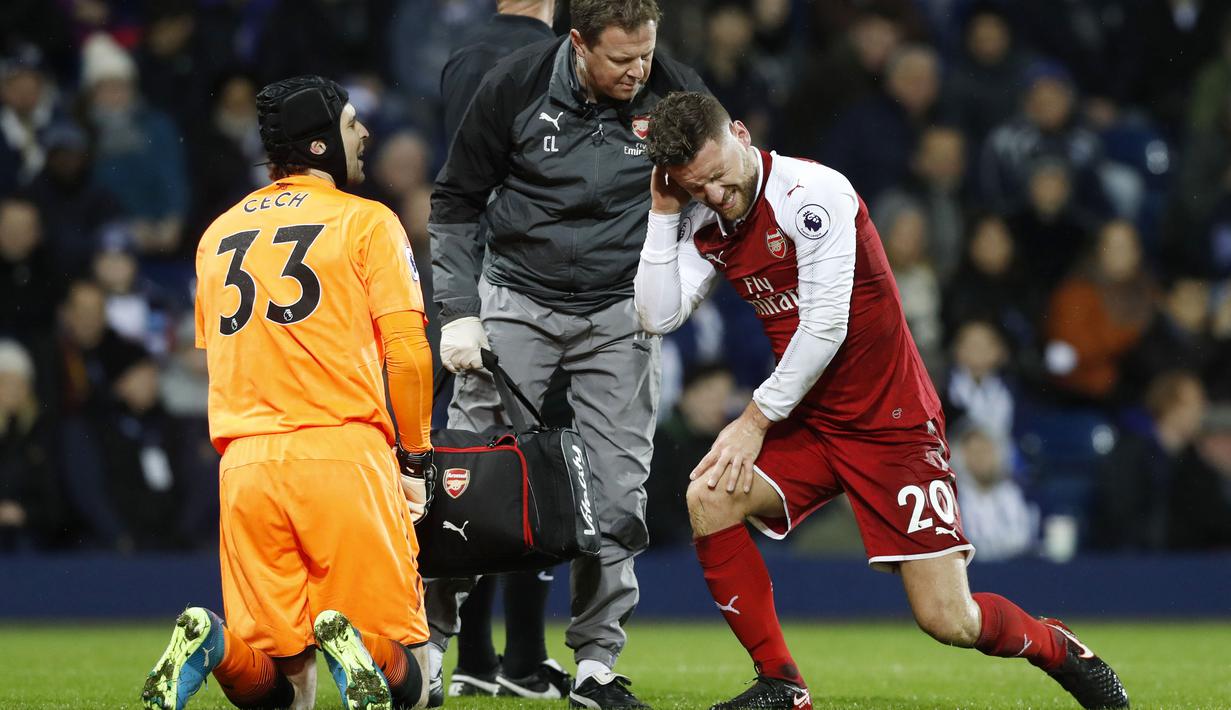 Pemain Arsenal, Shkodran Mustafi (kanan) mendapat perawatan medis saat melawan West Bromwich pada lanjutan Premier League di The Hawthorns, West Bromwich, (31/12/2017). Arsenal bermain imbang 1-1 dengan West Bromwich. (Martin Rickett/PA via AP)