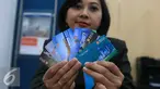 Petugas menunjukkan Kartu Tapcash Bank BNI di Jakarta, Selasa (18/10). Bank Indonesia (BI) menaikkan batas atas plafon uang elektronik menjadi Rp 10 juta yang sebelumnya hanya Rp 5 juta. (Liputan6.com/Angga Yuniar)