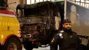 Petugas keamanan setempat berjaga di dekat truk yang menabrak kerumunan orang di Jalan Drottninggatan, pusat kota Stockholm, Swedia (8/4). (AP Photo / Markus Schreiber)