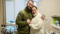 Tentara Ukraina Vitalii Khroniuk memeluk rekannya Anna Sokurenko saat kunjungan mereka ke klinik kesuburan IVMED di Kiev, Ukraina, 4 Februari 2023. Sadar bahwa dia bisa mati kapan saja, pria berusia 29 tahun itu memutuskan untuk mencoba cryopreservasi - proses pembekuan sperma atau sel telur yang dilakukan oleh beberapa tentara Ukraina karena mereka menghadapi kemungkinan tidak akan pernah pulang. (AP Photo/Evgeniy Maloletka)
