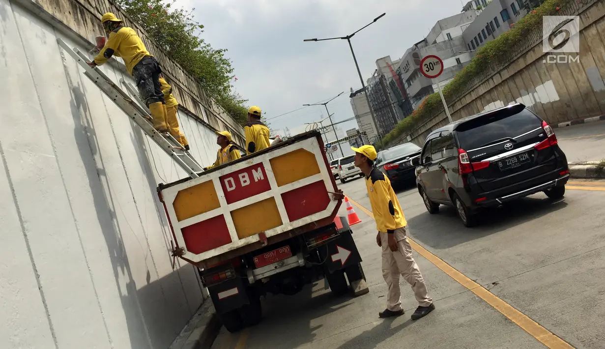 Suasana saat Pasukan Kuning mengecat dinding Underpass Kebayoran Baru, Jakarta Selatan, Kamis (1/2). Pengecatan dilakukan agar dinding underpass tidak kusam serta menghindari kesan kumuh. (Liputan6.com/Immanuel Antonius)