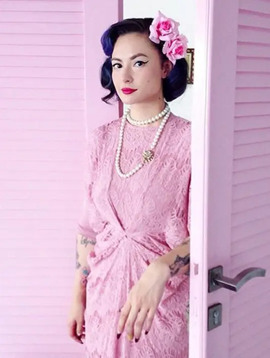 Meski menggunakan kaftan, Claudia Adinda tetap bergaya vintage dan pin up stylenya. Kali ini ia memilih serbapink, mulai dari baju sampai hiasan kepala yang berbentuk bunga pun berwarna pink. (Instagram/miss_adinda_mae)