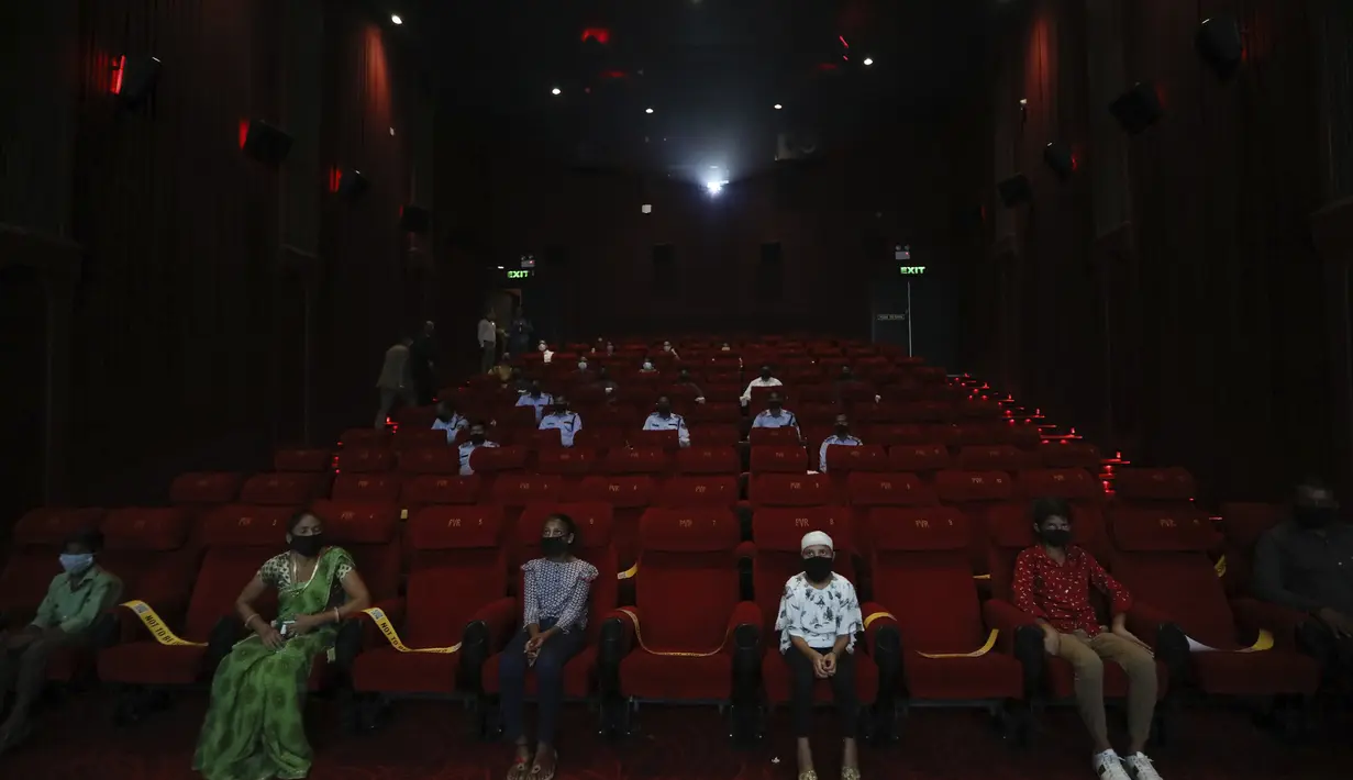 Orang-orang menonton film Bollywood India saat bioskop dibuka kembali dengan pemutaran khusus untuk pejuang COVID-19 dan keluarga mereka di bioskop PVR di New Delhi, India (15/101/2020). Kasus infeksi virus corona di negara itu terus meningkat hingga menembus angka 7,3 juta. (AP Photo/Manish Swarup)