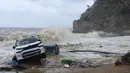 Mobil-mobil terlihat di tepi laut setelah badai petir hebat, di desa Paliokastro, di pulau Kreta, Yunani, Sabtu (15/10/2022). Dilaporkan setidaknya satu orang tewas dan lainnya hilang setelah banjir bandang yang parah. (AP Photo/Harry Nakos)