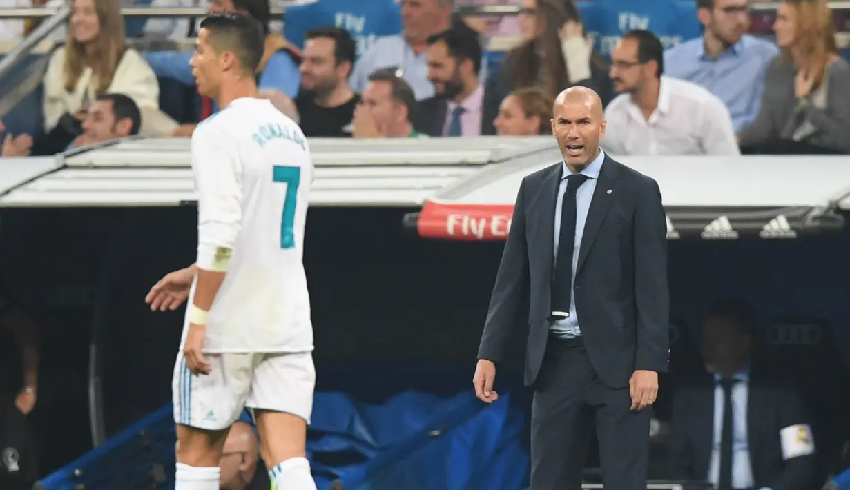 Pelatih Real Madrid, Zinedine Zidane, memberikan arahan kepada Cristiano Ronaldo, pada laga La Liga Spanyol di Stadion Santiago Bernabeu, Rabu (20/9/2017). Real Madrid kalah 0-1 dari Real Betis. (AFP/Gabriel Bouys)