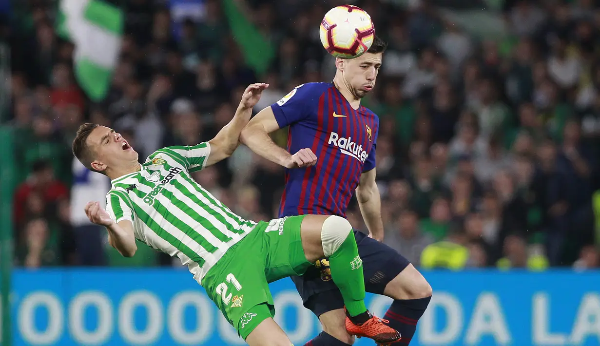 Bek Barcelona, Lenglet, berebut bola dengan pemain Real Betis, Lo Celso, pada laga La Liga 2019 di Stadion Benito Villamarin, Minggu (17/3). Barcelona menang 4-1 atas Real Betis. (AP/Miguel Morenatti)