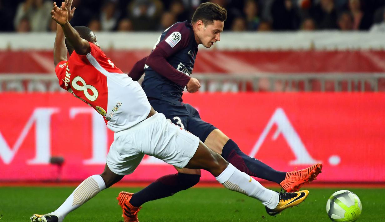 Aksi pemain AS Monaco, Almamy Toure (kiri) menahan laju pemain PSG, Julian Draxler pada lanjutan Ligue 1 di Louis II stadium, Monaco, (26/11/2017). PSG menang 2-1. (AFP/Anne-Christine Poujoulat)