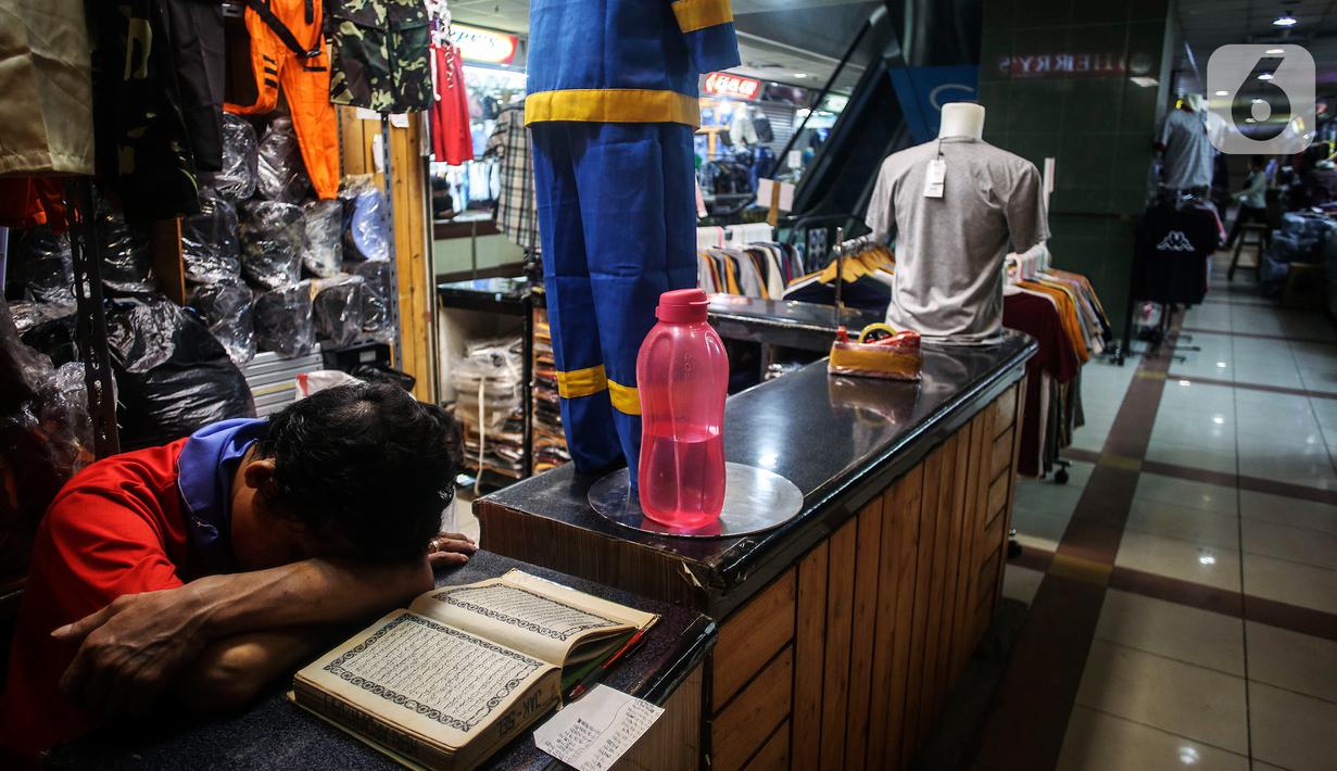 Pedagang tertidur di antara barang dagangannya di Pasar Tanah Abang, Jakarta, Selasa (27/7/2021). Pasar Tanah Abang yang kembali dibuka mulai Senin (26/7) mewajibkan pengunjung serta pedagang menunjukkan sertifikat vaksinasi COVID-19 untuk masuk ke pasar. (Liputan6.com/Johan Tallo)