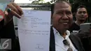 Pengacara Freddy Budiman, Untung Sunaryo menunjukkan surat yang ditulis langsung oleh Freddy Budiman, Cilacap, Jawa Tengah, Rabu (27/7). Menurut pengacaranya, Freddy hanya meminta dimakamkan di tanah kelahirannya (Surabaya). (Liputan6.com/Helmi Afandi)