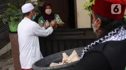 Sejumlah warga tengah membagikan nasi bungkus kepada warga yang terdampak Covid-19 di di RW 03, Kelurahan Gandasari, Kecamatan Jatiuwung, Kota Tangerang, Jumat (11/6/2021).  (Liputan6.com/Angga Yuniar)