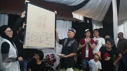 Ibunda Bimbim, Bunda Iffet (kiri) saat diberikan sebuah lukisan oleh suaminya yang merayakan ulang tahun di markas slank, jakarta, senin (18/01/2016). (Liputan.com/Herman Zakharia)