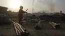Warga menyiapkan bambu usai pemerintah membongkar tenda pengungsian mereka di di Chuchepati, Kathmandu, Nepal, Selasa (14/3). Pemerintah Nepal terpaksa menggusur kamp ini karena sudah berdiri selama dua tahun. (AP Photo)