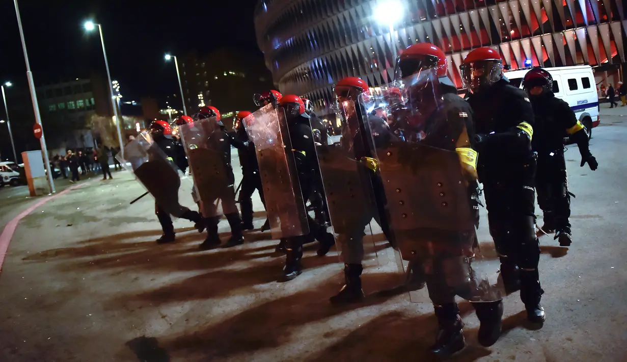 Polisi antihuru hara berjaga saat bentrok antara suporter Athletic Bilbao dan Spartak Moskow di Stadion San Mames, Bilbao, Spanyol, Kamis (22/2). Akibat bentrok tersebut seorang polisi meninggal. (AP Photo/Alvaro Barrientos)
