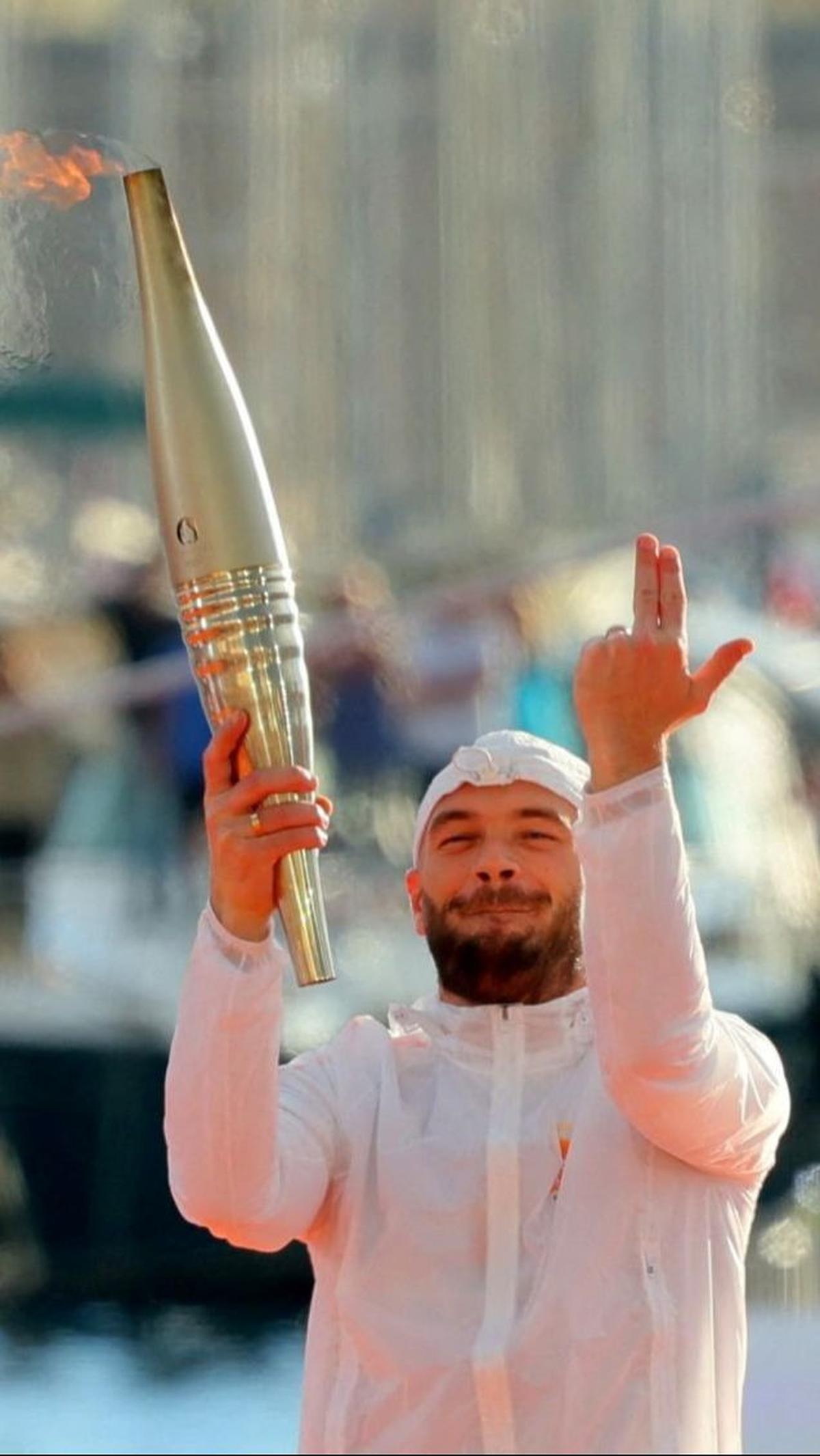 Pada kesempatan ini, Rapper Prancis, Julien Mari alias Jul dipercaya untuk memegang api obor Olimpiade 2024 saat menyambut kedatangannya di Pelabuhan Tua Paris.