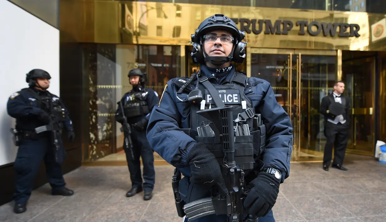 Personel NYPD berdiri di depan Trump Tower, New York, Kamis (10/11). Seiring dengan munculnya gelombang unjuk rasa anti Trump, markas Presiden terpilih AS itu kini dijaga ketat oleh sejumlah personel Departemen Kepolisian New York. (TIMOTHY A. CLARY/AFP)