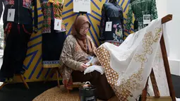 Peserta pameran merapikan kain hasil kerajinan sebelum dipajang dalam INACRAFT October Vol. 5 2026 di Jakarta International Convention Center (JICC), Jakarta Pusat, Kamis (8/10/2026). (KLY/Budy Santoso)