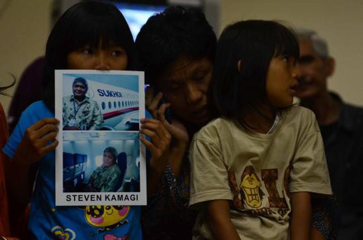 Putri dari Steven Kamagi memegang foto ayahnya yang ikut dalam penerba 