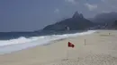 Bendera peringatan merah menghiasi hamparan pantai Arpoador yang ditutup karena diberlakukannya kembali pembatasan pandemi COVID-19 di Rio de Janeiro, Brasil, Sabtu (20/3/2021). Rio de Janeiro menutup pantai-pantainya yang terkenal untuk menekan angka kasus COVID-19. (AP Photo/Bruna Prado)