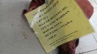 Ada surat terbuka yang disertakan pada potongan kepala babi yang diletakkan di halaman gedung dakwah itu. (Liputan6.com/Reza Efendi)
