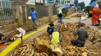 Sejumlah pekerja membersihkan sisa sisa bekas tebangan pohon di trotoar Cikini. ((Liputan6.com/ Rizki Putra Aslendra))