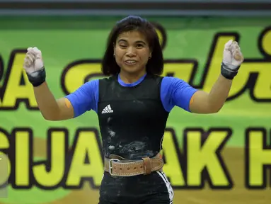 Lifter Jabar, Sri Wahyuni Agustiani bersorak usai mengangkat beban di kelas 48 kg PON XIX Jabar di Gelora Sabilulungan, Kab Bandung, Selasa (20/9). Total angkatan Sri Wahyuni 182 Kg sekaligus memecahkan rekor nasional. (Liputan6.com/Helmi Fithriansyah)