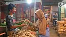 Pedagang melayani pembeli jahe di Pasar Induk Kramat Jati, Jakarta, Kamis (5/3/2020). Harga jahe mengalami kenaikan dari Rp25 ribu perkilogram kini dibanderol Rp35 ribu karena dipercaya mampu menangkal penyebaran virus corona Covid-19 yang sudah masuk Indonesia. (Liputan6.com/Herman Zakharia)