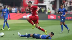 Pemain depan Persija, Marko Simic melompat menghindari tekel pemain Arema FC pada lanjutan Shopee Liga 1 Indonesia 2019 di Stadion Gelora Bung Karno, Jakarta, Sabtu (3/8/2019). Laga berakhir imbang 2-2. (Liputan6.com/Helmi Fithriansyah)