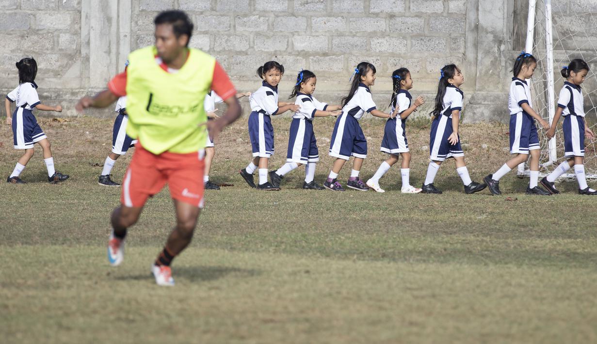 Sejumlah anak-anak SD berolahraga dengan berbagi lapangan bersama pemain Persija yang sedang latihan jelang laga Piala Presiden melawan Persita di Lapangan Trisakti, Bali, Rabu (2/9/2015). (Bola.com/Vitalis Yogi Trisna) 